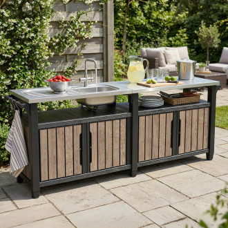 Barek ogrodowy Keter Deco Unity Chef 415L Ashwood z metalowym blatem i zlewem ustawiony na tarasie w ogrodzie