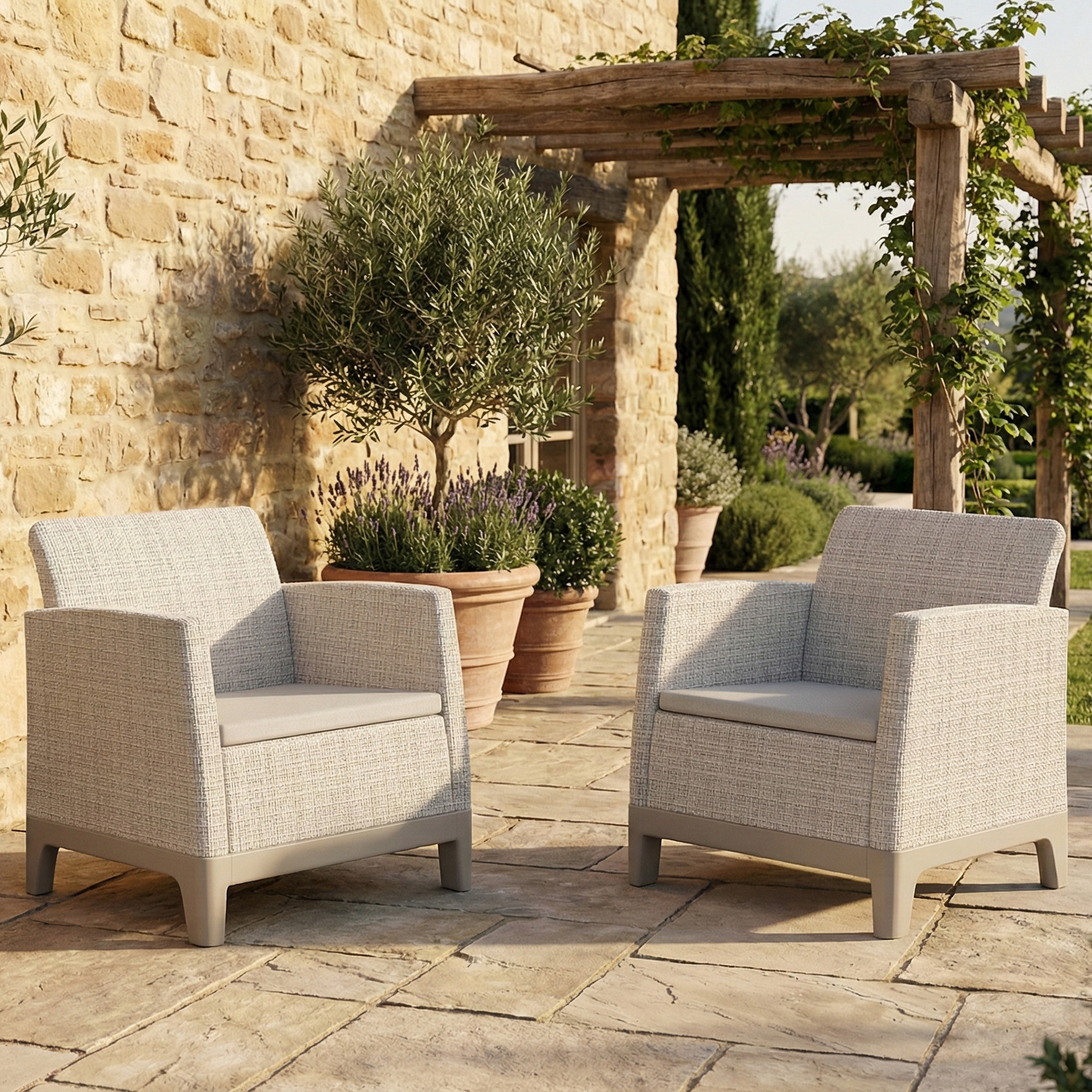 Dwa fotele ogrodowe Scandi Forma Duo w kolorze Pebble Grey-Soft Beige stojące na słonecznym tarasie przy kamiennej ścianie
