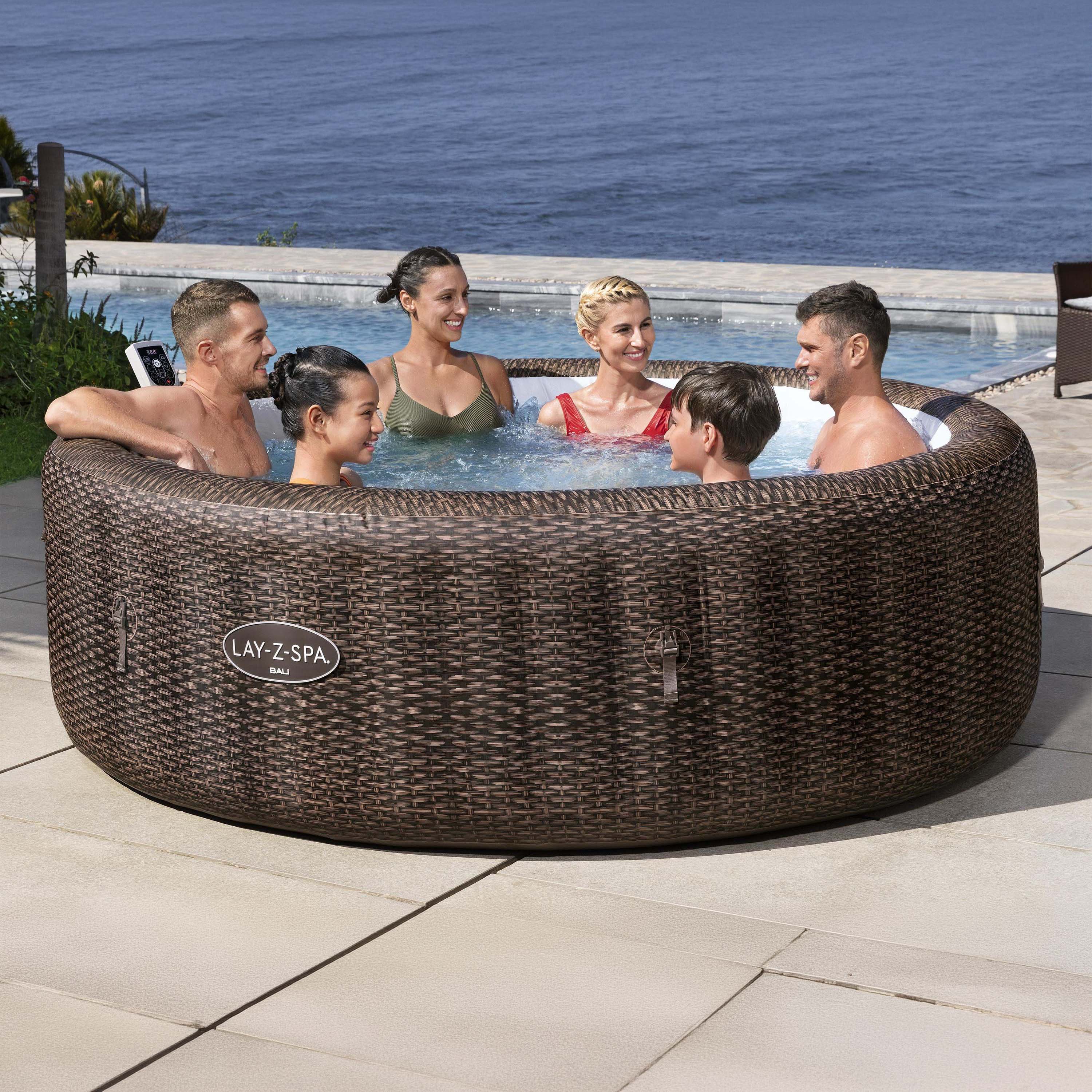 Jacuzzi dmuchane LAY-Z-SPA BALI Smart AirJet w brązowym rattanowym oplocie z rodziną relaksującą się w wodzie