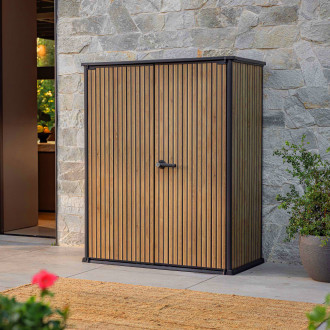 Schowek ogrodowy Deco Vertical 1400L Venetian Brown Keter z dwuskrzydłowymi drzwiami na tle kamiennej ściany budynku