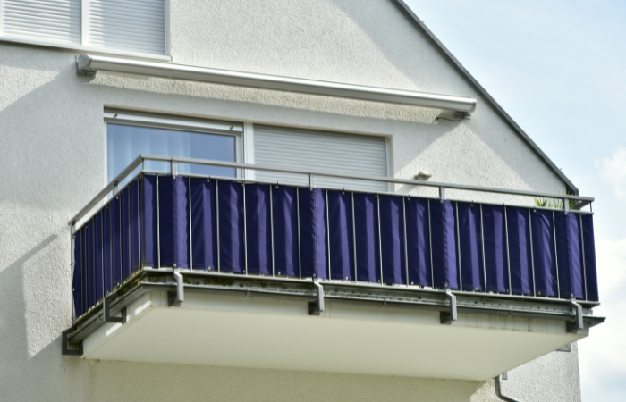 Balkon z poręczą ze stali wysokiej jakości w budynku mieszkalnym z granatową osłoną balkonową